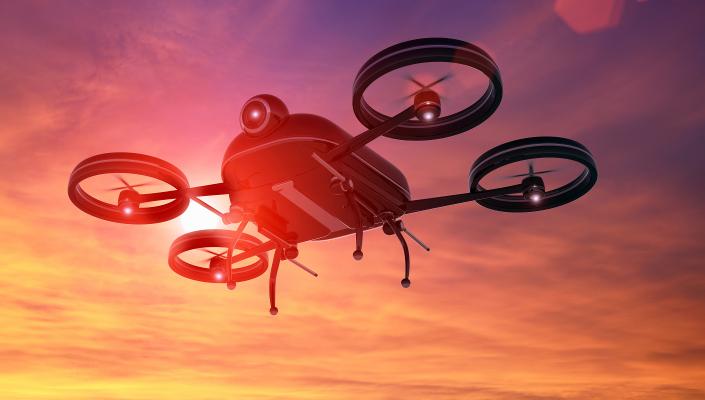 illustration of a drone flying against a sunset sky