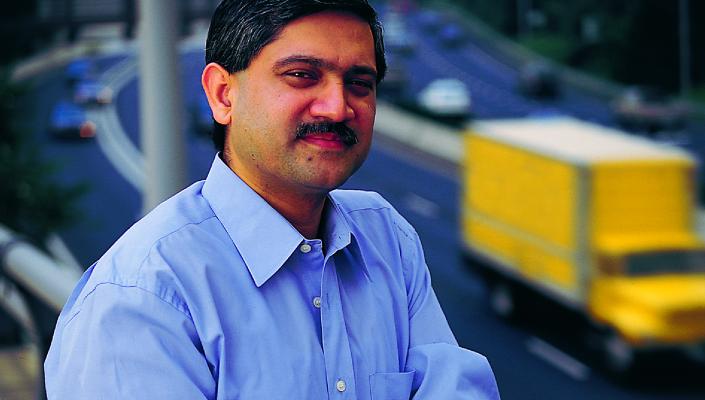 Adnan Hyder stands on a bridge with a highway behind him