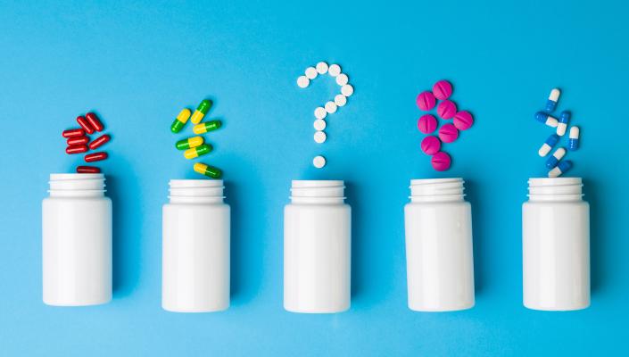  Prescription bottles and pills forming a question mark