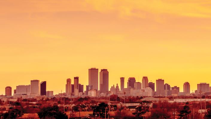 The summer sun sets over the skyline in New Orleans.