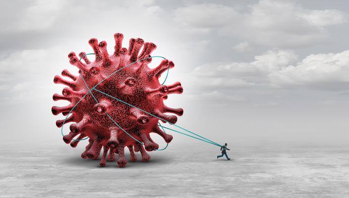 An illustration of a person pulls a giant SARS-CoV-2 virus behind them like a weight.