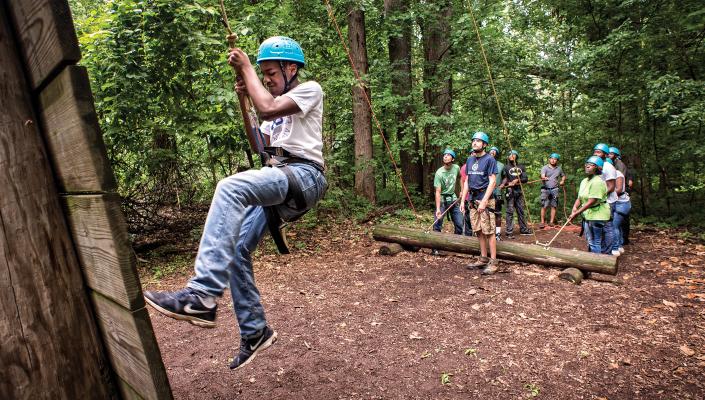 A child climbs on a ropes course during the police-youth program at the Baltimore Chesapeake Bay Outward Bound School.