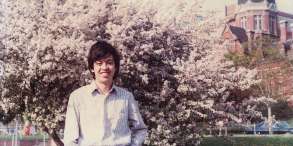 Chien-Jen Chen stands in front of a tree in bloom with the Hopkins dome in the background.