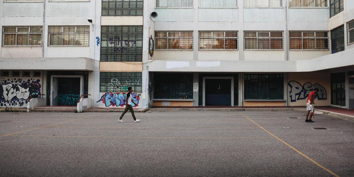 Image of refugees playing cricket in an abandoned school yard