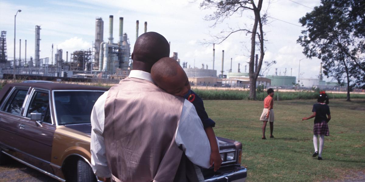A family leaving church services surrounded by chemical plants