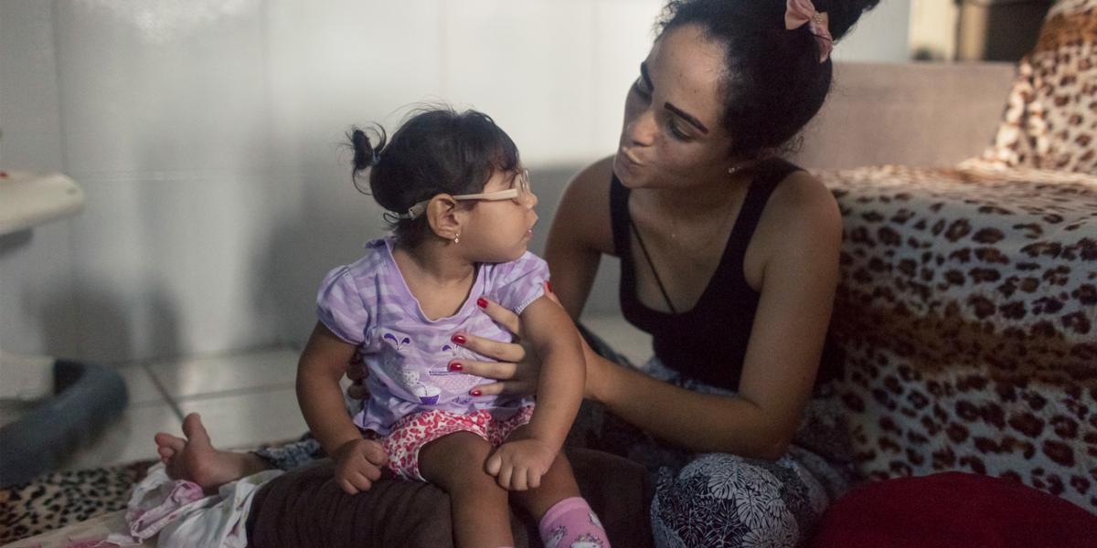 Dhulha Alen Silva do Nascimento and her daughter, Valentina, share a moment at home.