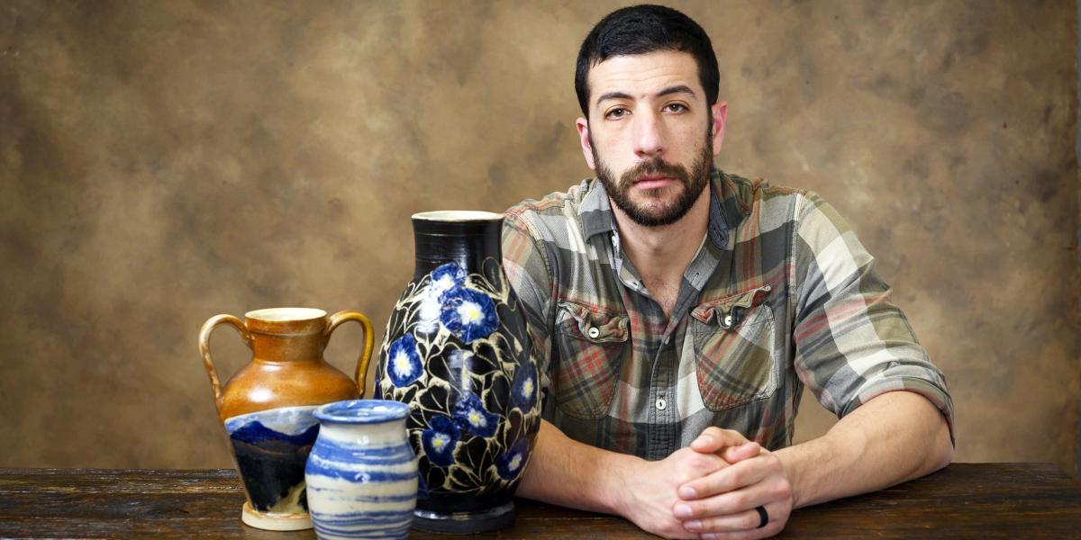 Adrian Weiss poses with some of his pottery.