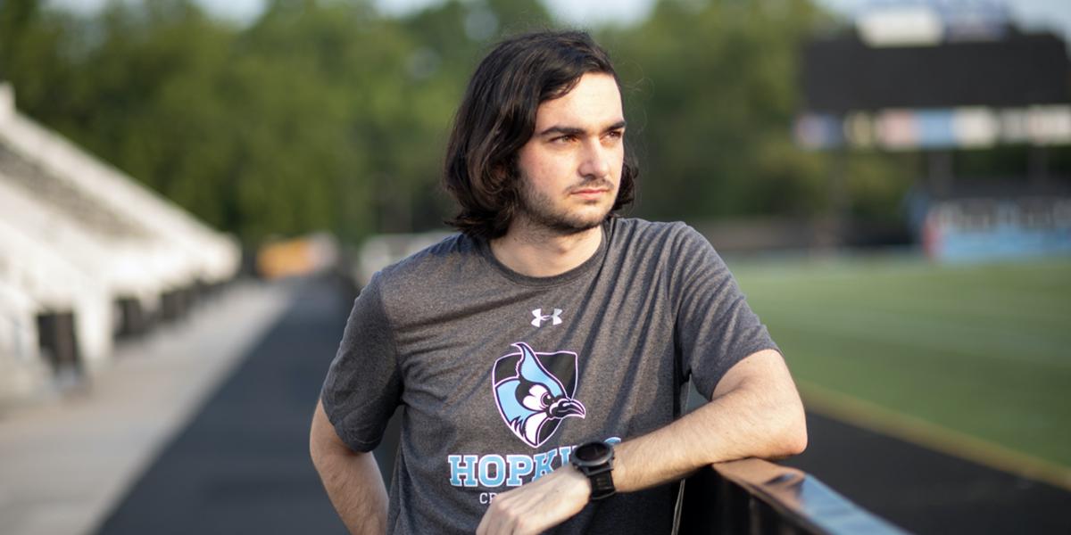 Chris Wilhelm leans on a fence at the Johns Hopkins track