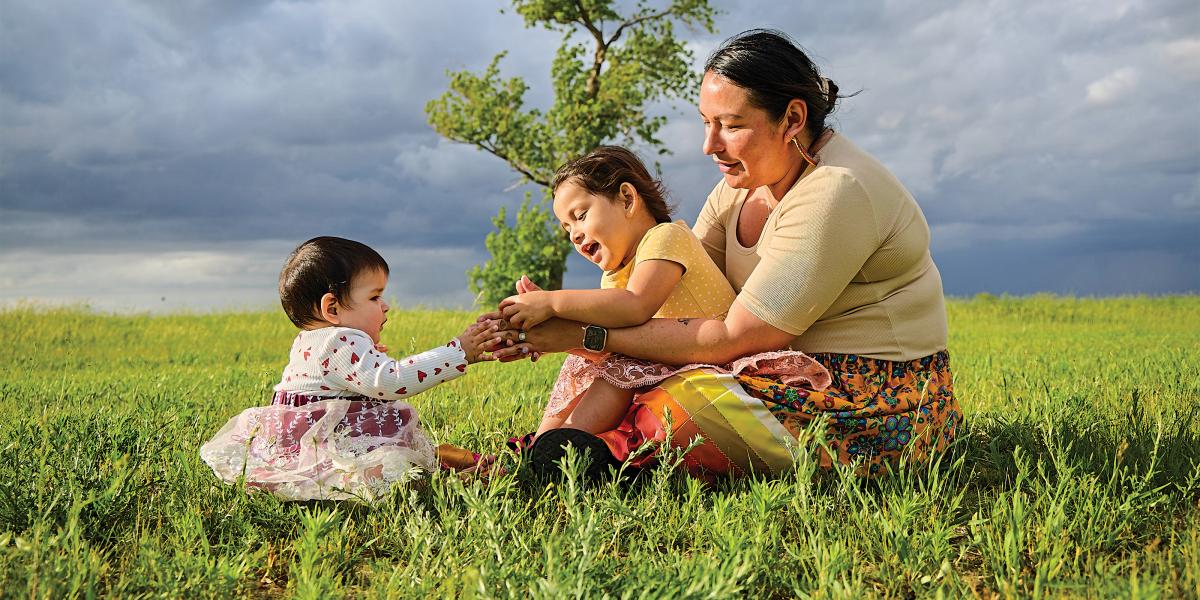 Red Lake Band of Chippewa  member Vernelle Lussier sits with daughters Brielle (left) and Zoie Chaboyea beside Red Lake in Minnesota in June 2022.