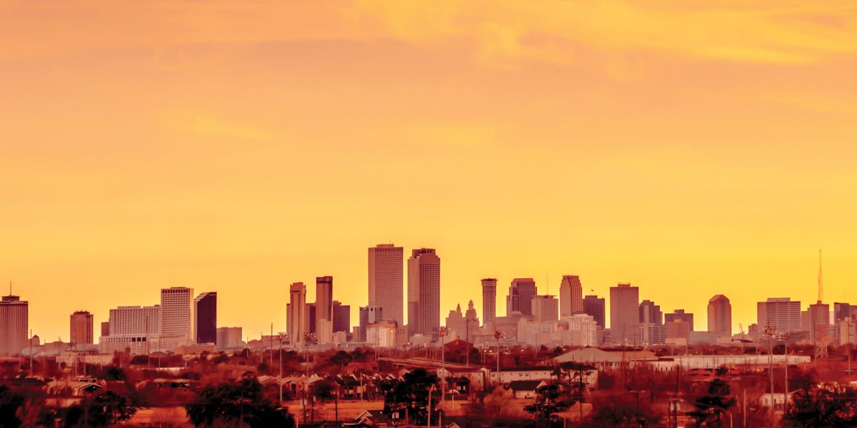 The summer sun sets over the skyline in New Orleans.