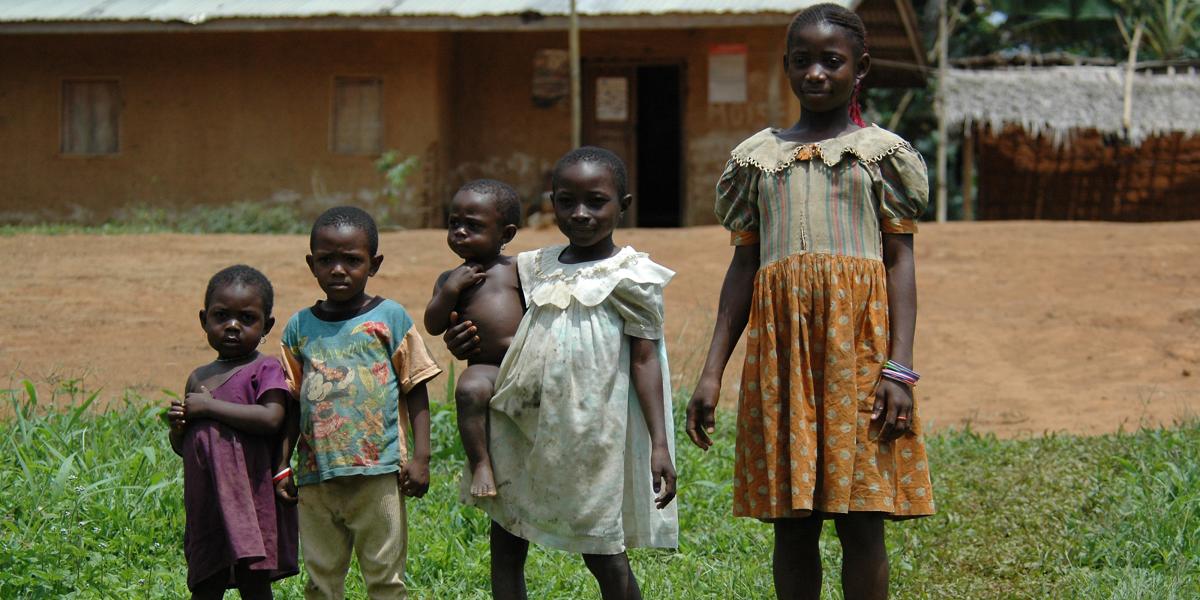 4 children standing in line youngest to oldest; one child holds a toddler on her hip.