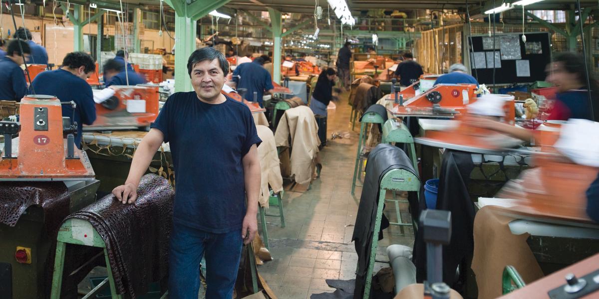 A man stands on a busy textile plant workroom floor.