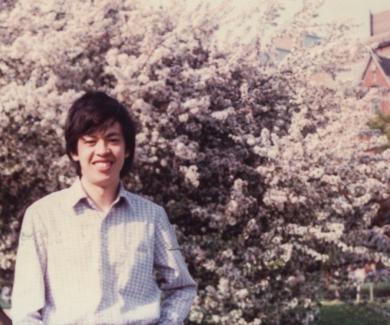 Chien-Jen Chen stands in front of a tree in bloom with the Hopkins dome in the background.