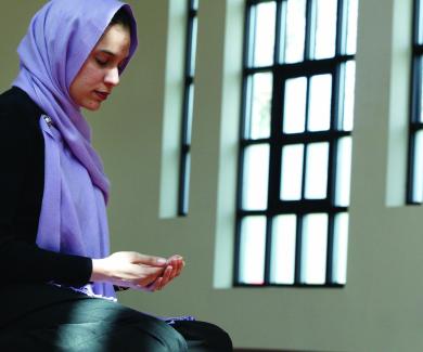 Maliha Ilias, doctoral student in Population and Family Health Sciences, kneels in prayer