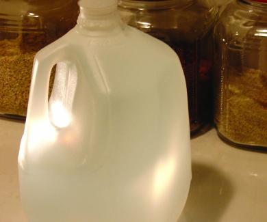 a gallon bottle of water and canisters of rice and other staples