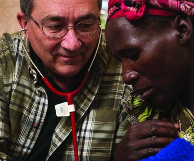 Philip Thuma listens to a man's lungs with a stethoscope