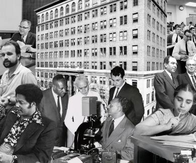 A collage of black and white photographs of the Bloomberg School's history. Images include the exterior of the school, students in class, and professors.