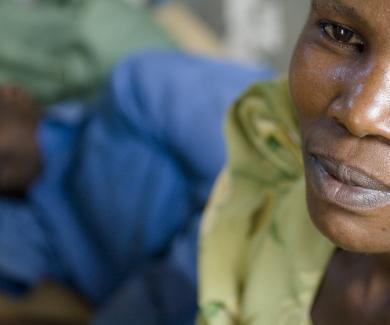 A Ugandan woman sits with a patient at a clinic run by the Rakai Health Sciences Program