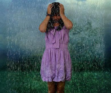 a teenage girl in a purple dress under a rain cloud